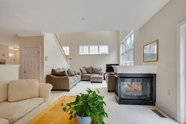 carpeted living room featuring a multi sided fireplace