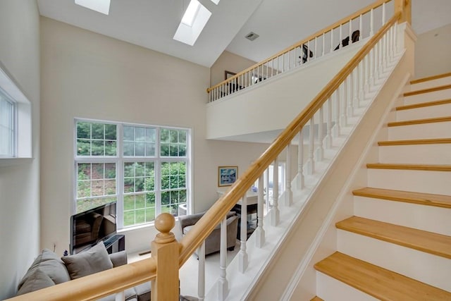 staircase featuring high vaulted ceiling