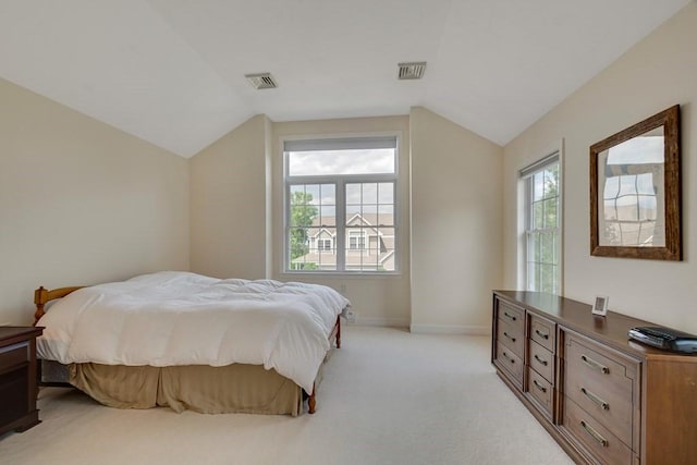 bedroom with vaulted ceiling and light carpet