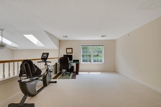 workout room featuring a skylight and light colored carpet