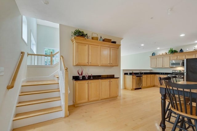 kitchen with stainless steel appliances, light hardwood / wood-style flooring, and light brown cabinets