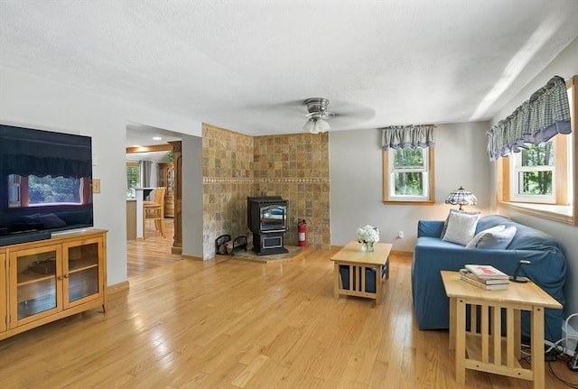 6 Hillcrest Dr, Hopkinton, MA 01748 - living area featuring healthy amount of natural light, a ceiling fan, light wood-style flooring, and a wood stove