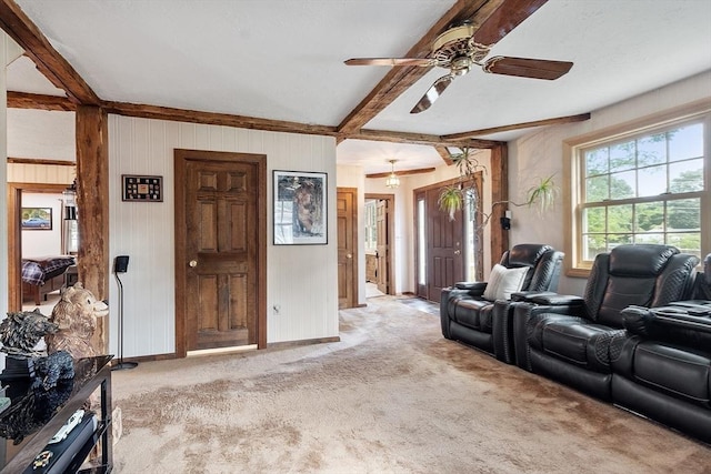 living room with beamed ceiling, light colored carpet, and ceiling fan