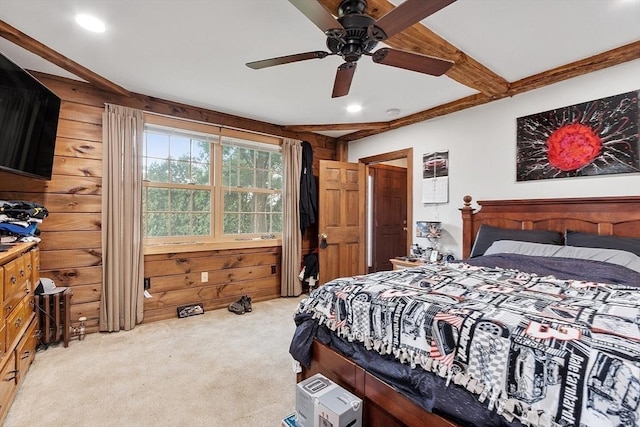 bedroom featuring ceiling fan, light colored carpet, beam ceiling, and wood walls