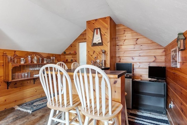 interior space featuring lofted ceiling, wooden walls, and dark hardwood / wood-style floors