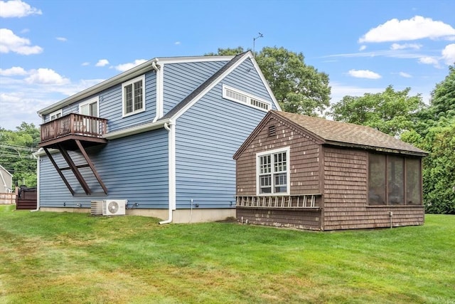 back of house featuring ac unit, a yard, and a sunroom