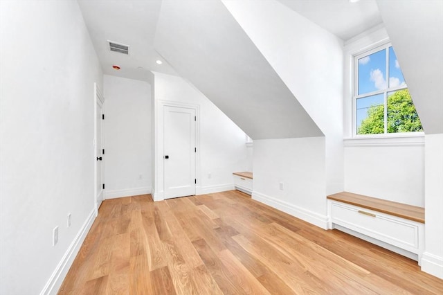 additional living space featuring light wood-style floors, recessed lighting, baseboards, lofted ceiling, and visible vents