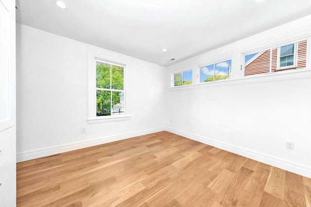 empty room with recessed lighting, baseboards, and light wood-type flooring