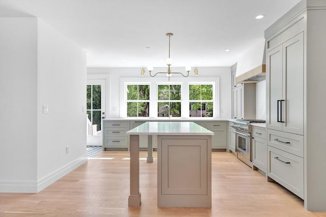 kitchen with custom exhaust hood, light countertops, a chandelier, a sink, and stainless steel appliances