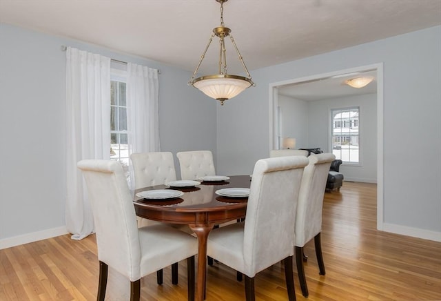 dining room with baseboards and light wood finished floors