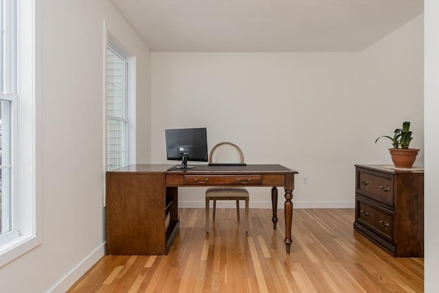 home office with baseboards and light wood-type flooring