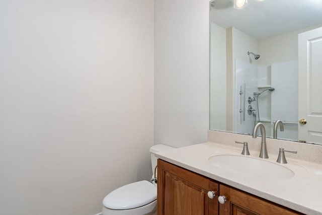 bathroom featuring a shower, toilet, and vanity