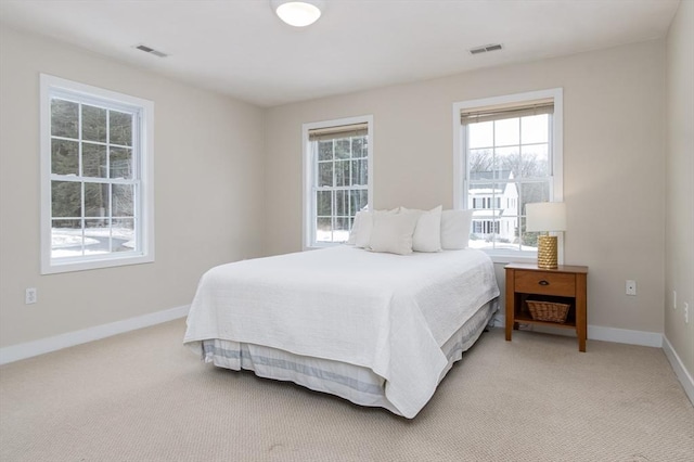 bedroom featuring light colored carpet, baseboards, and visible vents