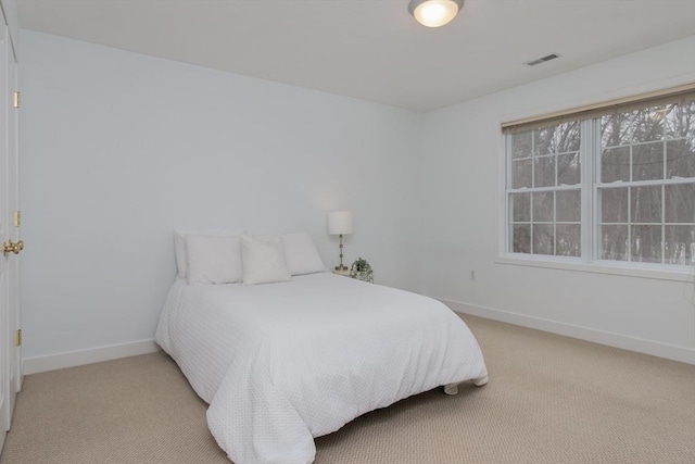 bedroom with light colored carpet, visible vents, and baseboards