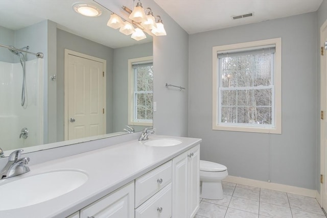 bathroom featuring double vanity, toilet, visible vents, and a sink