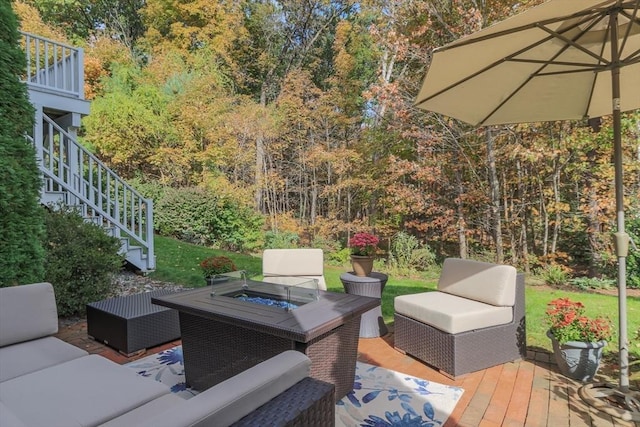 wooden terrace with an outdoor living space with a fire pit and stairs