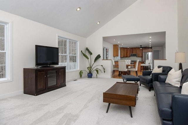 living area featuring recessed lighting, light colored carpet, baseboards, and high vaulted ceiling