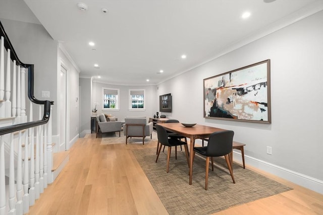 dining area with ornamental molding and light wood-type flooring