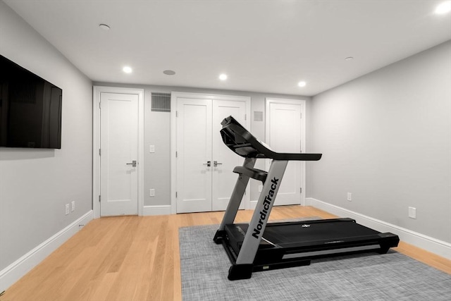 exercise room with light hardwood / wood-style floors