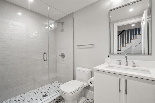 bathroom featuring vanity, a shower with shower door, and toilet