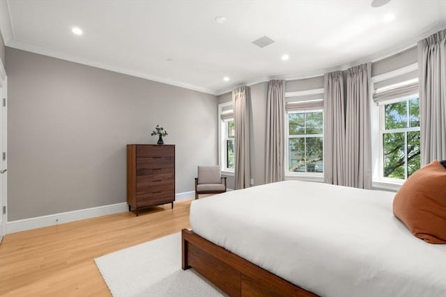 bedroom with crown molding and hardwood / wood-style floors