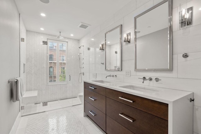 bathroom featuring vanity, toilet, an enclosed shower, and tile walls