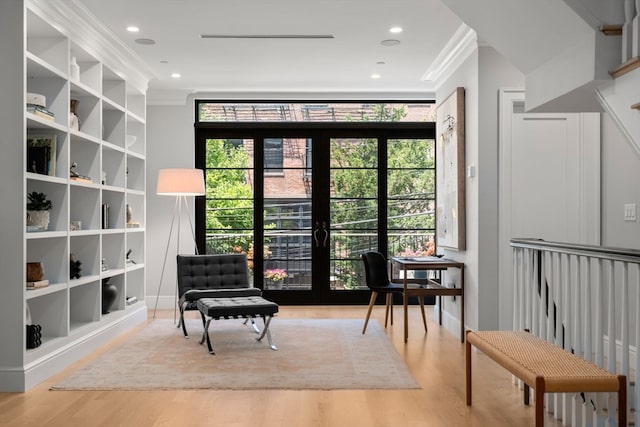 living area with french doors, light wood-type flooring, and crown molding