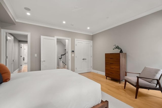 bedroom featuring crown molding and light wood-type flooring