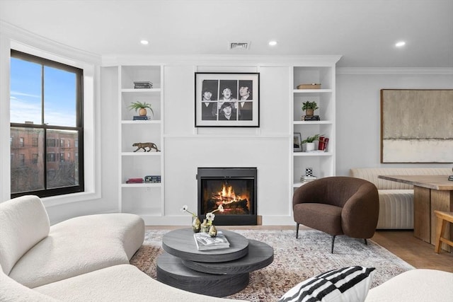 living room featuring built in shelves and crown molding