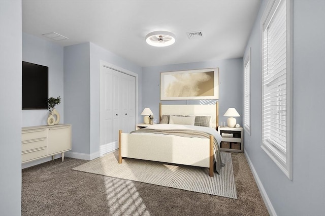 carpeted bedroom featuring multiple windows and a closet