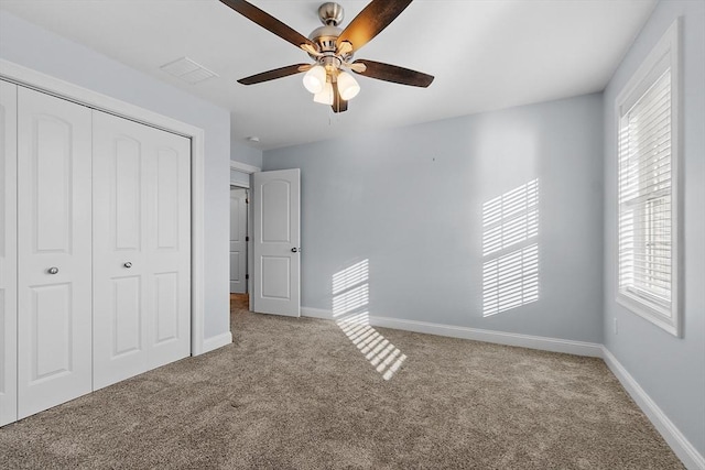 unfurnished bedroom featuring carpet, ceiling fan, and a closet