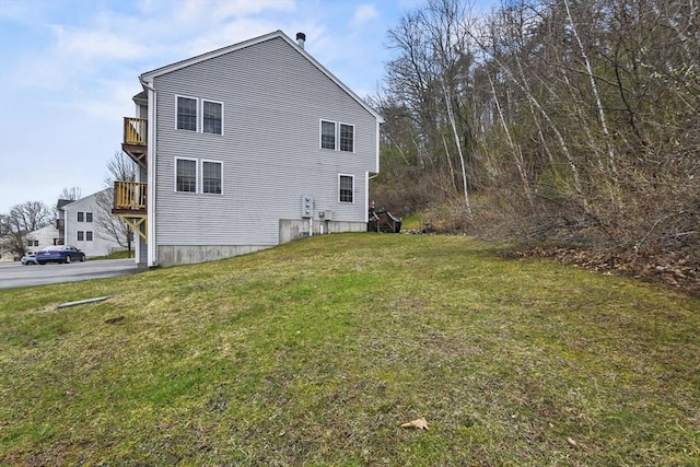 view of home's exterior featuring a lawn and a balcony
