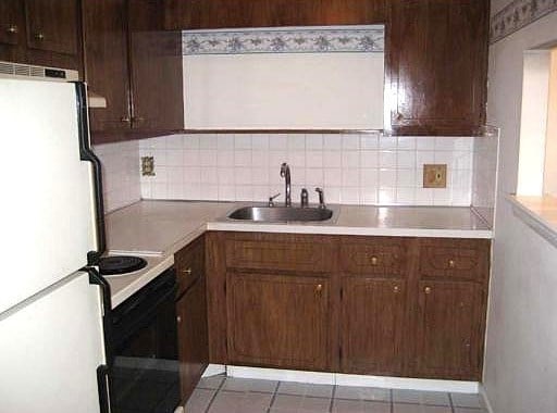 kitchen with tasteful backsplash, white refrigerator, sink, dark brown cabinetry, and electric range