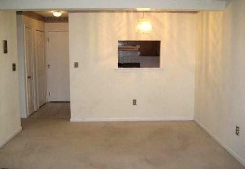 carpeted spare room featuring baseboards