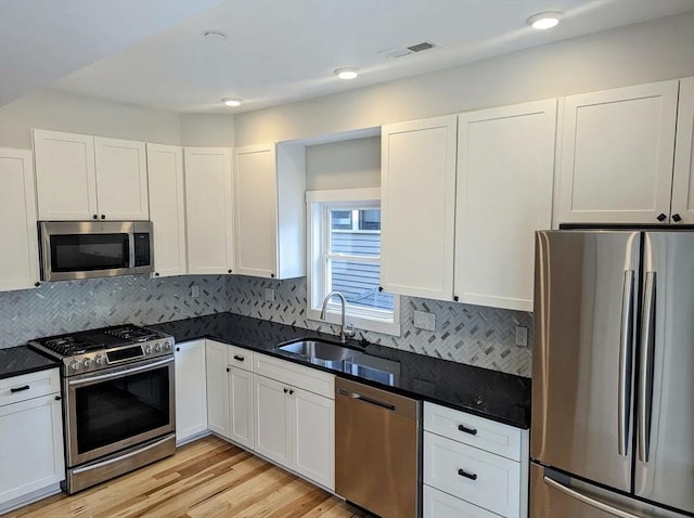 12 Perry St, Brookline, MA 02445 - kitchen with appliances with stainless steel finishes, a sink, white cabinetry, and recessed lighting