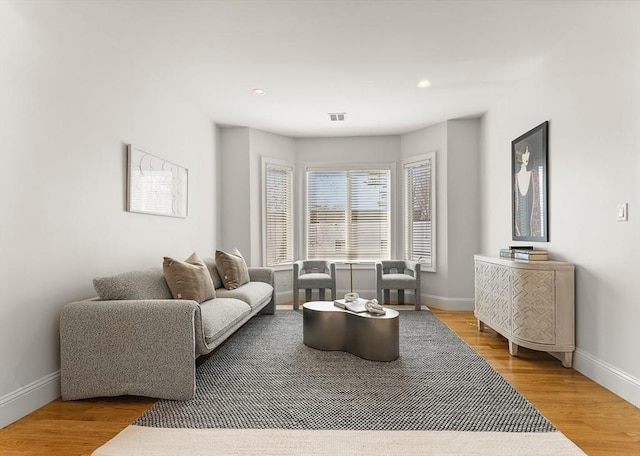 living area with recessed lighting, wood finished floors, and baseboards