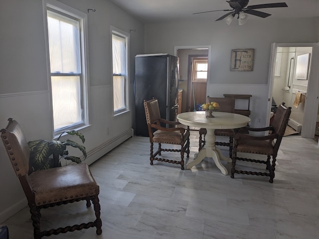 dining space featuring ceiling fan and baseboard heating