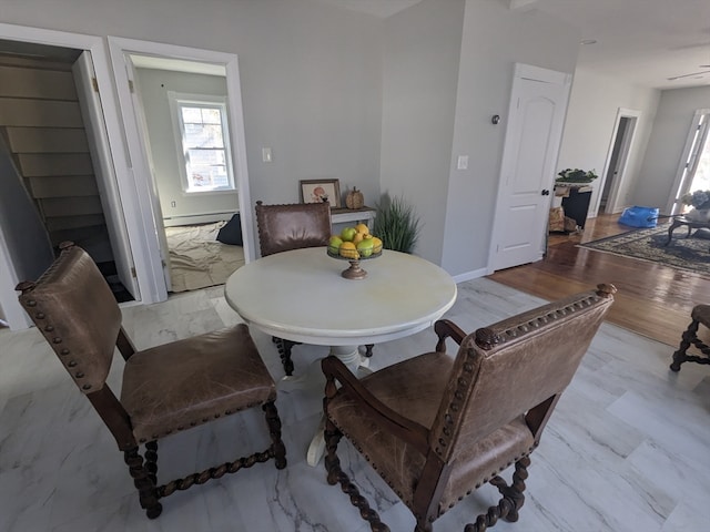 dining space with light wood-type flooring and baseboard heating