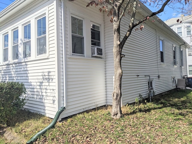 view of home's exterior featuring cooling unit and a yard