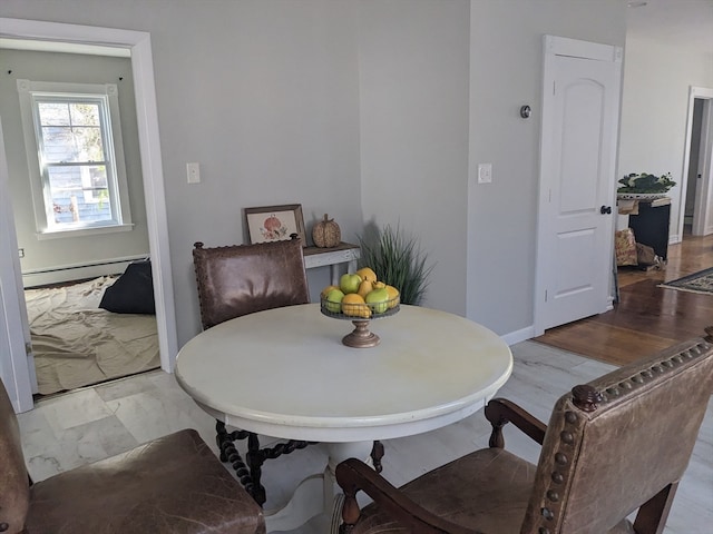 dining room with light wood-type flooring and baseboard heating