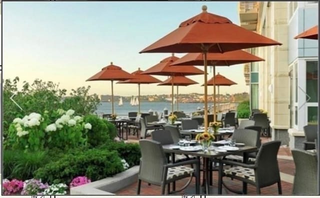 patio terrace at dusk featuring a water view