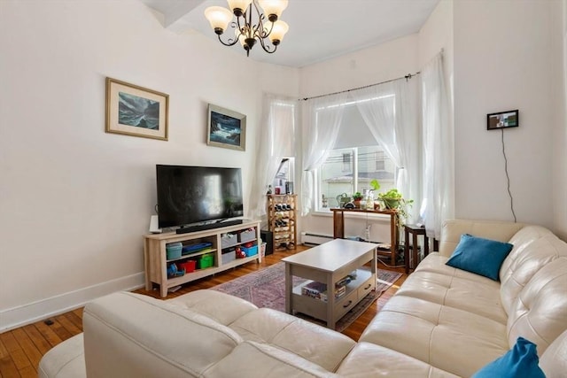 living area featuring a chandelier, wood finished floors, and baseboards