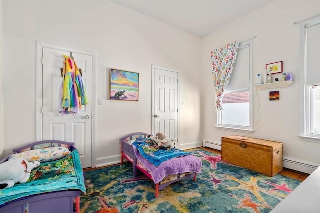bedroom with baseboard heating and wood finished floors