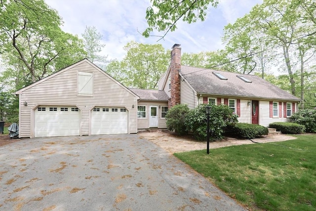 view of front of property featuring driveway, an attached garage, a chimney, a front lawn, and a shingled roof