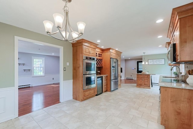 kitchen featuring appliances with stainless steel finishes, wainscoting, a chandelier, baseboard heating, and recessed lighting
