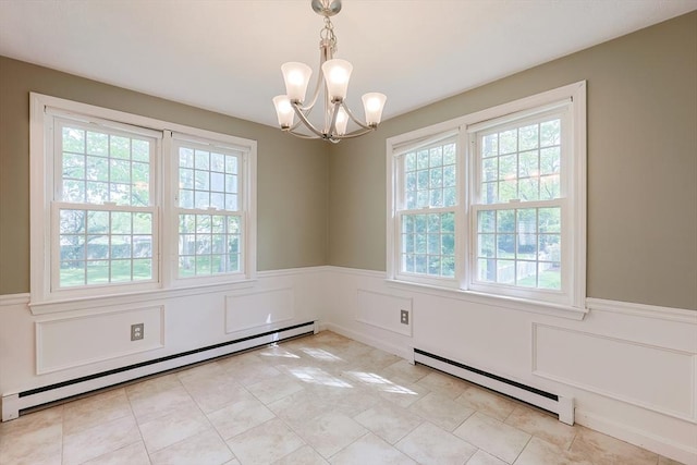 empty room featuring a baseboard radiator, a baseboard heating unit, wainscoting, healthy amount of natural light, and a chandelier