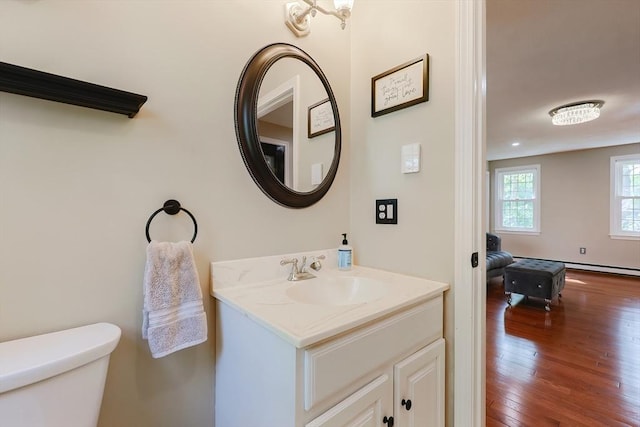 bathroom with wood finished floors, toilet, and vanity