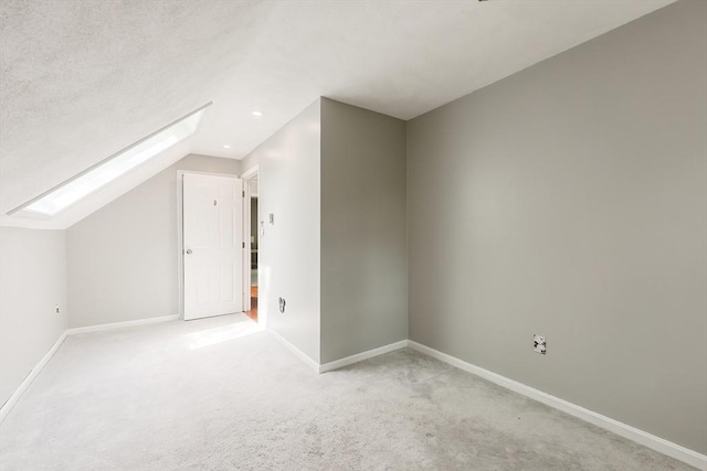 bonus room with a skylight, vaulted ceiling, baseboards, light carpet, and recessed lighting