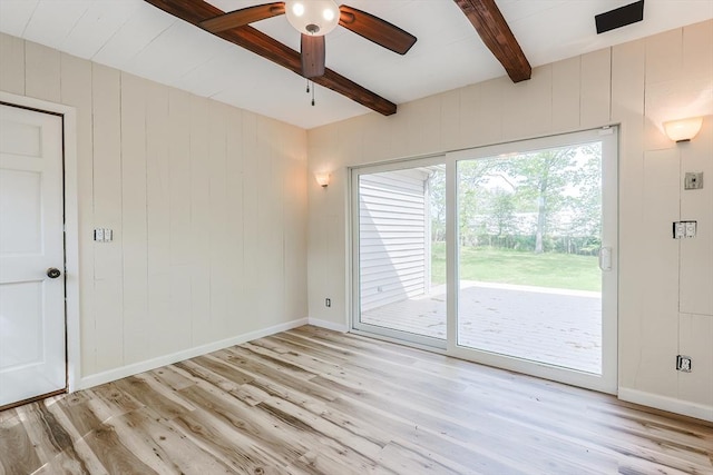spare room featuring beam ceiling, light wood-type flooring, baseboards, and a ceiling fan