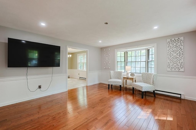living area featuring baseboard heating, wood finished floors, and recessed lighting
